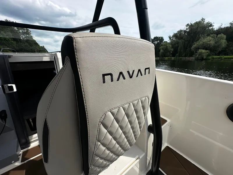 Slide: The Image of 2024 Navan S30 boat seat with logo, featuring quilted design, near a serene river. - 25