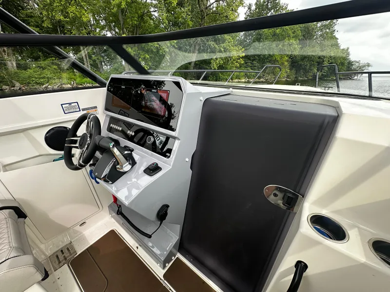 Slide: The Image of 2024 Navan S30 boat cockpit with modern steering and control panel, surrounded by lush greenery. - 27