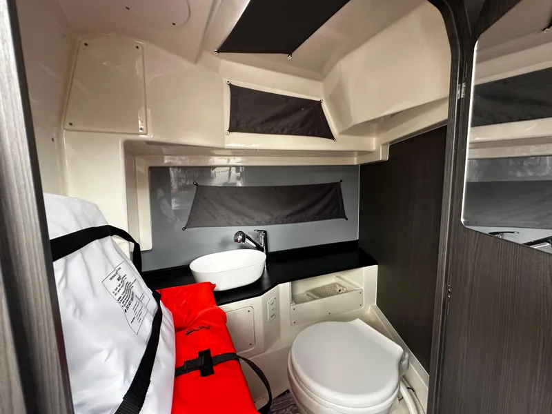 Slide: The Image of 2024 Navan S30 boat interior with compact bathroom, featuring a sink, toilet, and storage. - 47