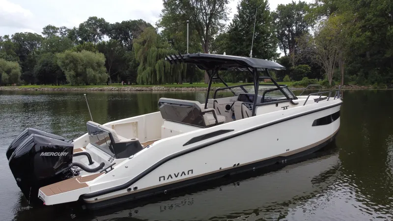 Slide: The Image of 2024 Navan S30 boat on a calm lake with lush green trees in the background. - 8