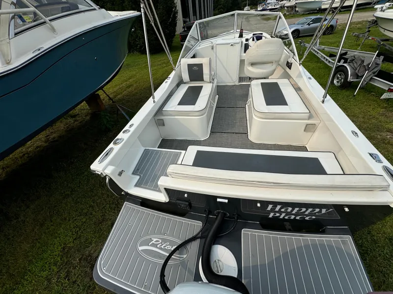 Slide: The Image of 2019 Eastern 21 Pilot boat with cushioned seating, docked on grass. - 10