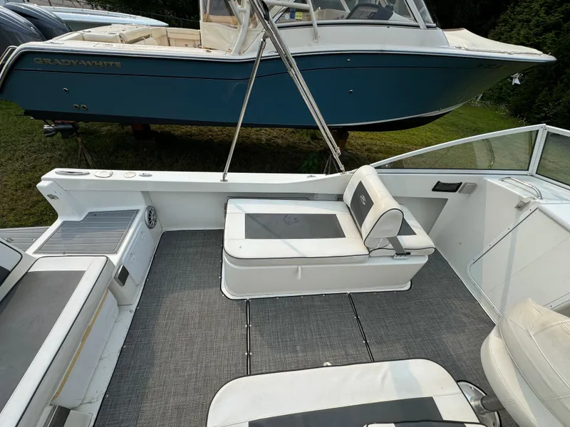 Slide: The Image of 2019 Eastern 21 Pilot boat interior with seating and storage, parked near a blue Grady-White boat. - 13