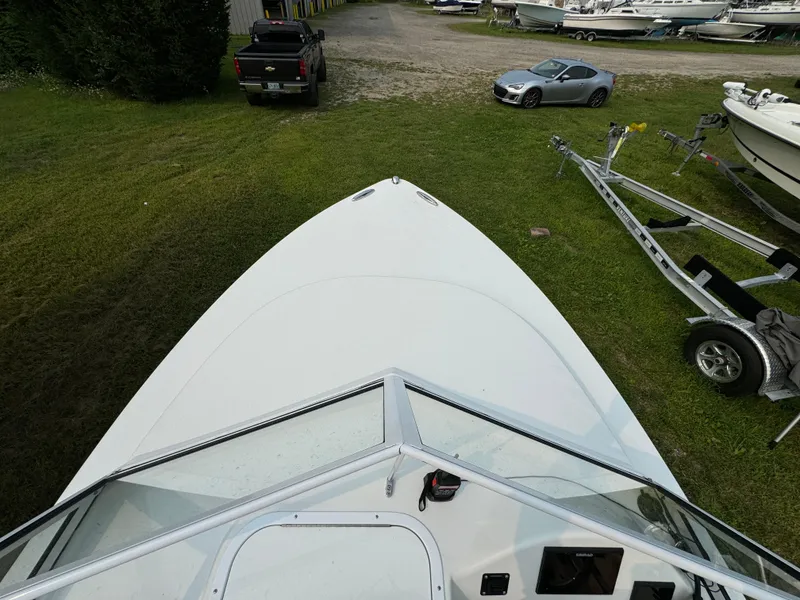 Slide: The Image of 2019 Eastern 21 Pilot boat on grass, with trailer and vehicles nearby. - 22