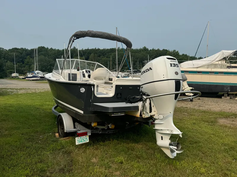 Slide: The Image of 2019 Eastern 21 Pilot boat with Honda 135 outboard motor on trailer, parked on grass. - 5