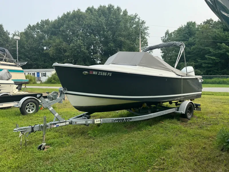 Slide: The Image of 2019 Eastern 21 Pilot boat on trailer, parked on grass with trees in background. - 6