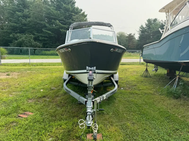 Slide: The Image of 2019 Eastern 21 Pilot boat on trailer, parked on grass with trees in background. - 8