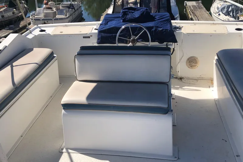 Slide: The Image of 1994 Gibson 50 Cabin Yacht helm with cushioned seating and steering wheel. - 14