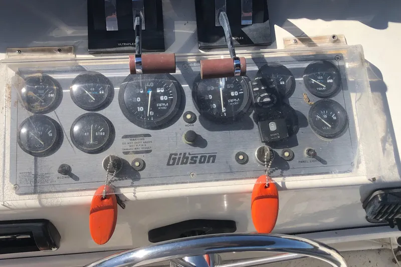Slide: The Image of Control panel of a 1994 Gibson 50 Cabin Yacht with gauges and throttle levers. - 15