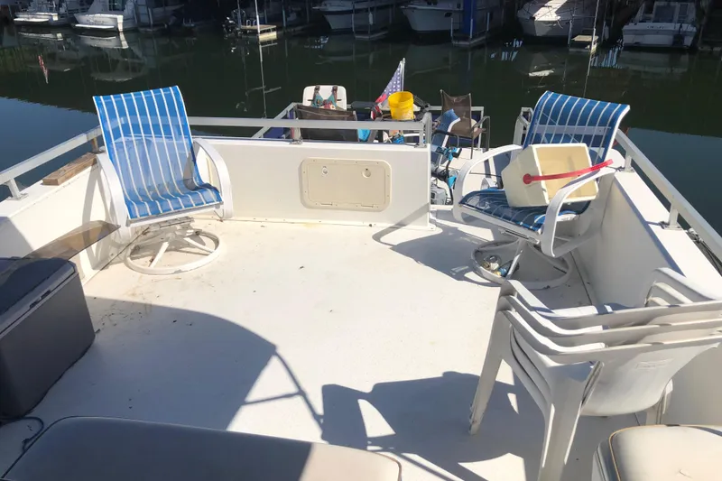 Slide: The Image of 1994 Gibson 50 Cabin Yacht deck with chairs and marina view. - 17