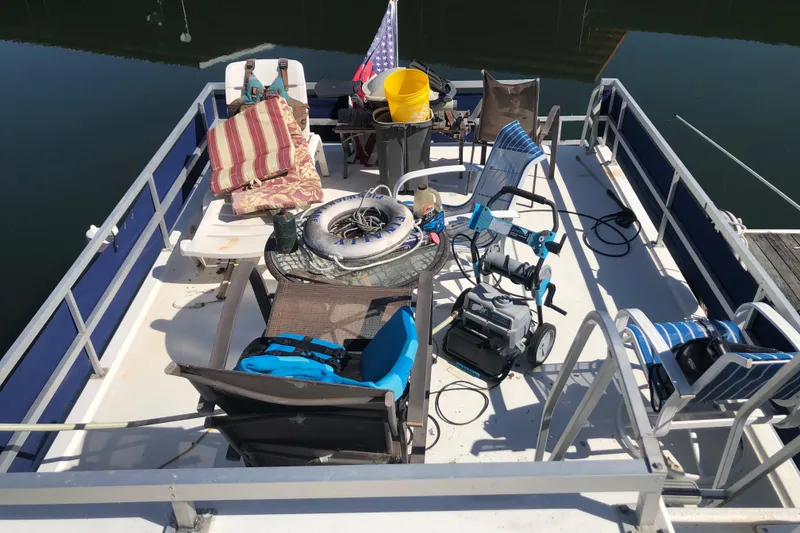 Slide: The Image of 1994 Gibson 50 Cabin Yacht deck with chairs, equipment, and American flag. - 18