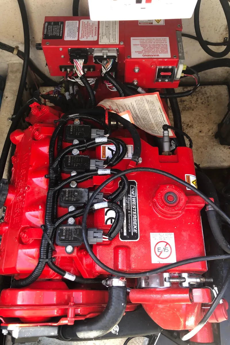 Slide: The Image of Engine compartment of a 1994 Gibson 50 Cabin Yacht, featuring a red engine and wiring. - 22