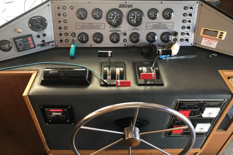 Slide: The Image of 1994 Gibson 50 Cabin Yacht control panel with steering wheel and instrument gauges. - 26
