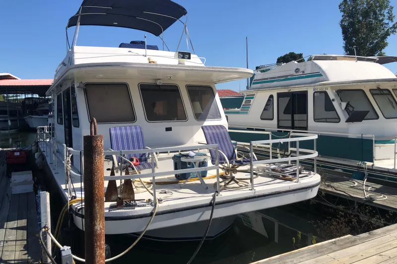 Slide: The Image of 1994 Gibson 50 Cabin Yacht docked at marina, featuring spacious deck and canopy. - 4