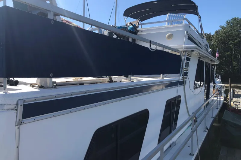 Slide: The Image of 1994 Gibson 50 Cabin Yacht docked, featuring sleek design and spacious deck. - 6