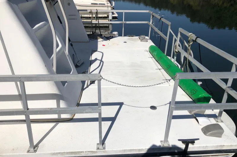 Slide: The Image of 1994 Gibson 50 Cabin Yacht deck with railing and green fender on calm water. - 7