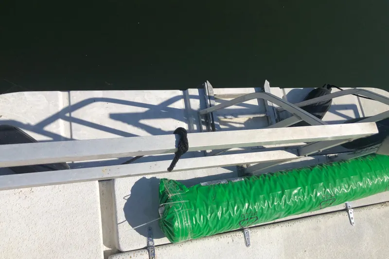 Slide: The Image of 1994 Gibson 50 Cabin Yacht deck with green fender and metal railings. - 9
