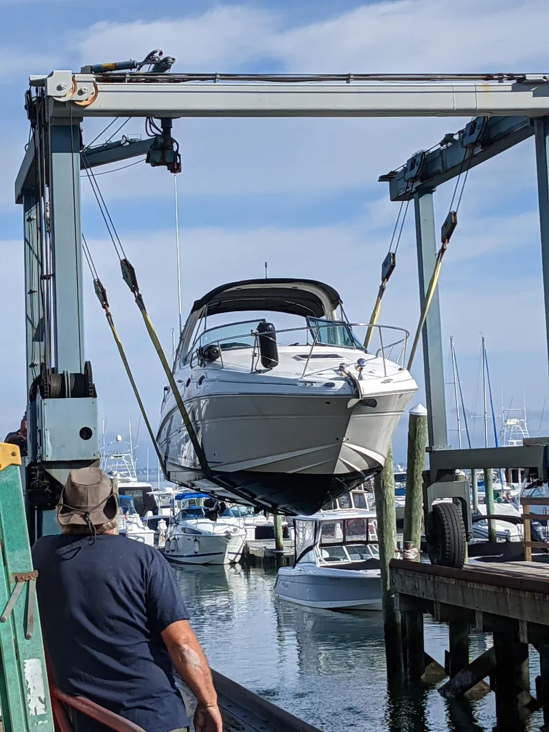 Slide: The Image of 2005 Sea Ray 280 Sundancer being lifted at a marina. - 2