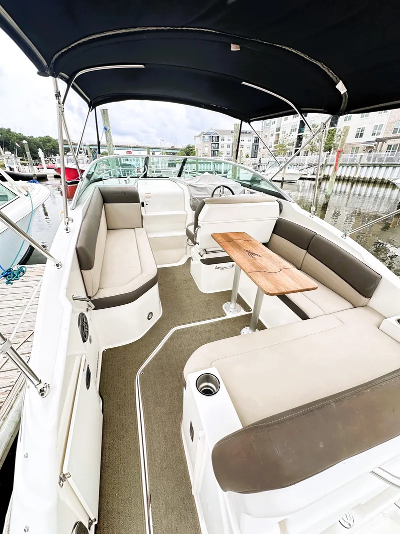 Slide: The Image of 2015 Sea Ray 260 Sundancer boat interior with seating and table, docked at marina. - 8