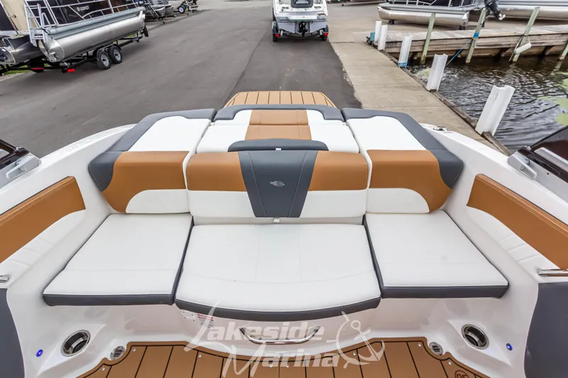 Slide: The Image of 2025 Chaparral 21 SSi boat interior with cushioned seating at marina. - 15