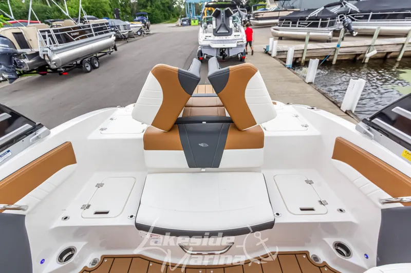 Slide: The Image of 2025 Chaparral 21 SSi boat interior with tan and white seating at marina. - 16