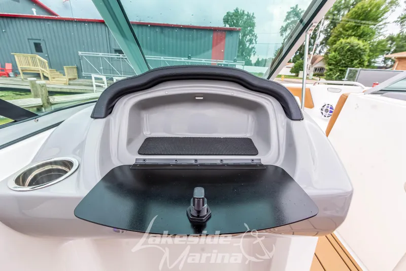 Slide: The Image of 2025 Chaparral 21 SSi boat dashboard with storage compartment and cup holder. - 30