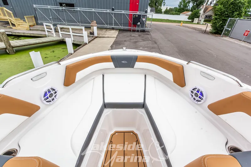 Slide: The Image of 2025 Chaparral 21 SSi boat interior with tan and white seating, dockside view. - 34