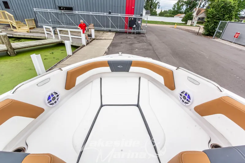 Slide: The Image of 2025 Chaparral 21 SSi boat interior with tan and white seating at dock. - 36