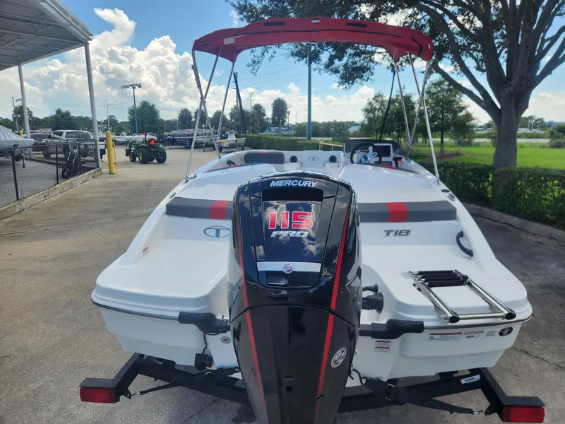Slide: The Image of 2024 Tahoe T18 boat with Mercury 115 engine, parked outdoors. - 2