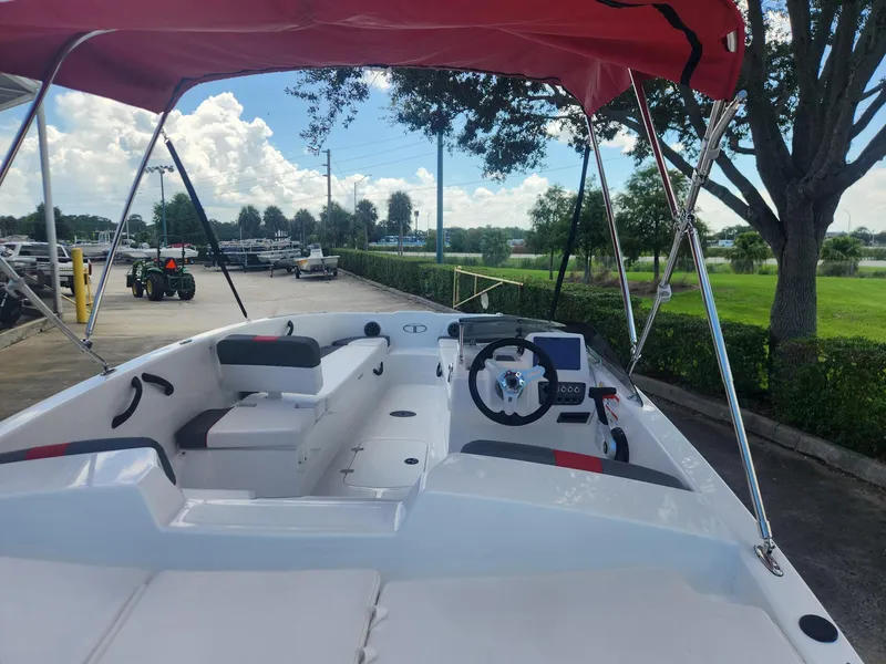 Slide: The Image of 2024 Tahoe T18 boat with red canopy, parked outdoors. - 3