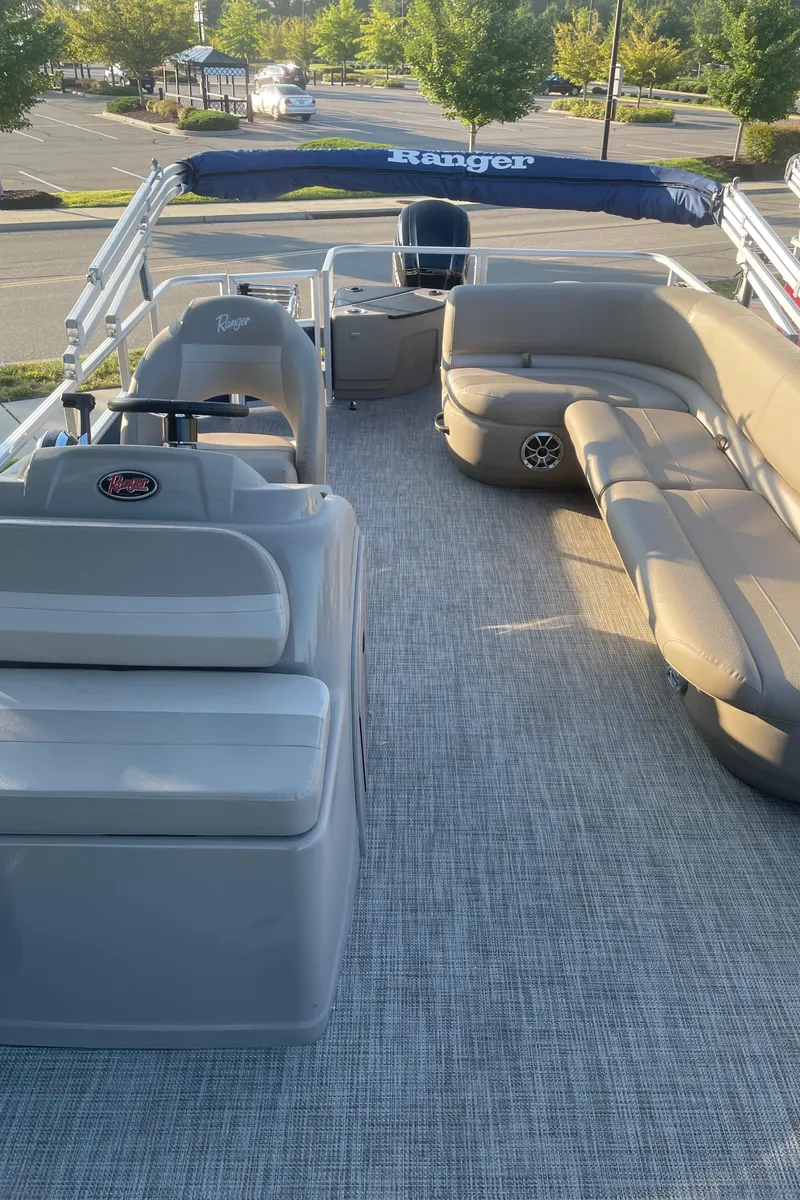 Slide: The Image of 2024 Ranger Reata 200F pontoon boat with spacious seating and modern design. - 2