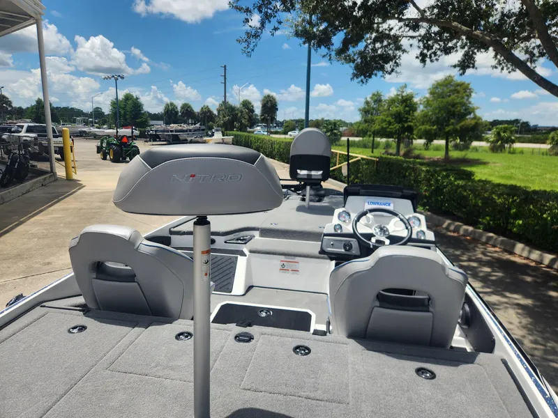 Slide: The Image of 2024 Nitro Z20 boat interior with steering wheel and seating, parked outdoors. - 3