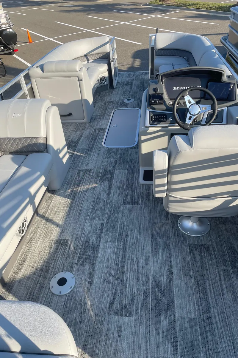 Slide: The Image of 2024 Ranger Reata 223C pontoon boat interior with modern seating and steering console. - 4
