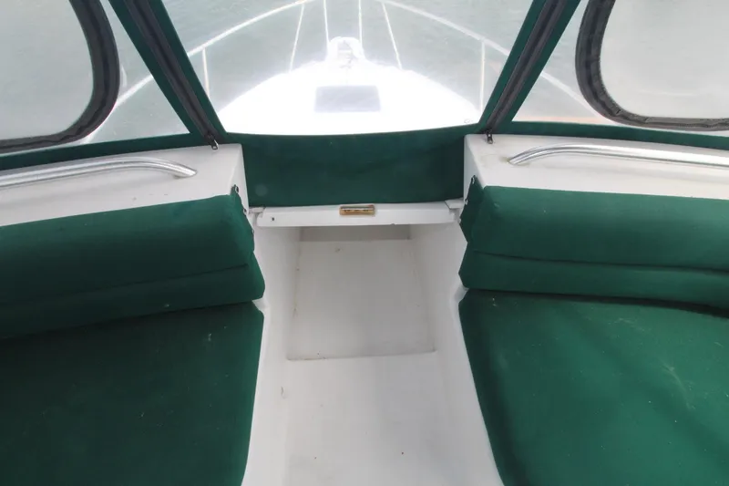 Slide: The Image of 1999 Mainship 31 Sedan Bridge interior with green seating and windows. - 10