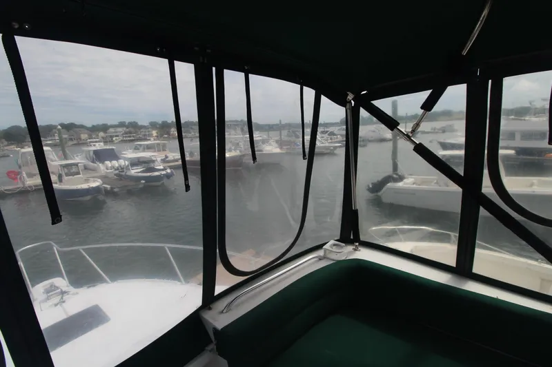 Slide: The Image of 1999 Mainship 31 Sedan Bridge interior view overlooking marina with multiple boats docked. - 11