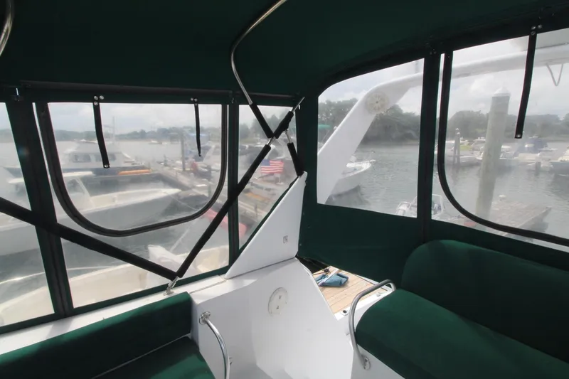 Slide: The Image of Interior view of 1999 Mainship 31 Sedan Bridge with marina backdrop. - 13