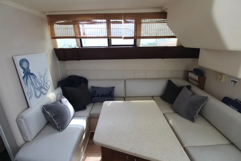 Slide: The Image of Interior of 1999 Mainship 31 Sedan Bridge with cozy seating and nautical decor. - 18