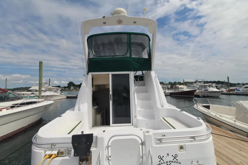 Slide: The Image of 1999 Mainship 31 Sedan Bridge docked at marina, featuring spacious deck and cabin. - 2