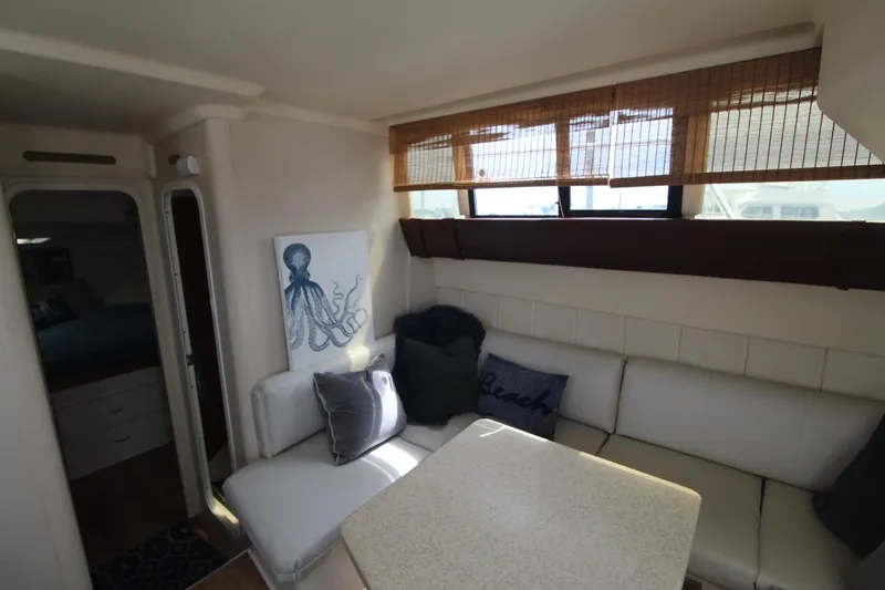 Slide: The Image of Interior of 1999 Mainship 31 Sedan Bridge with cozy seating and nautical decor. - 21