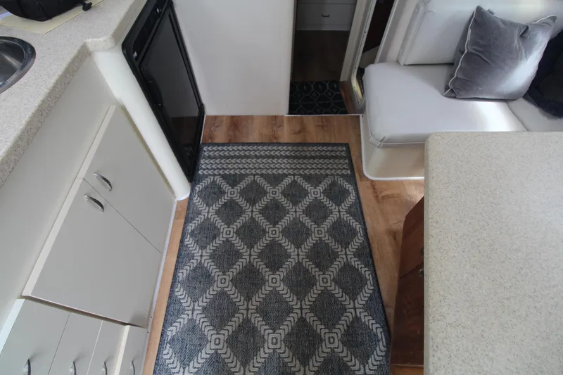 Slide: The Image of Interior of 1999 Mainship 31 Sedan Bridge with patterned rug and seating area. - 23