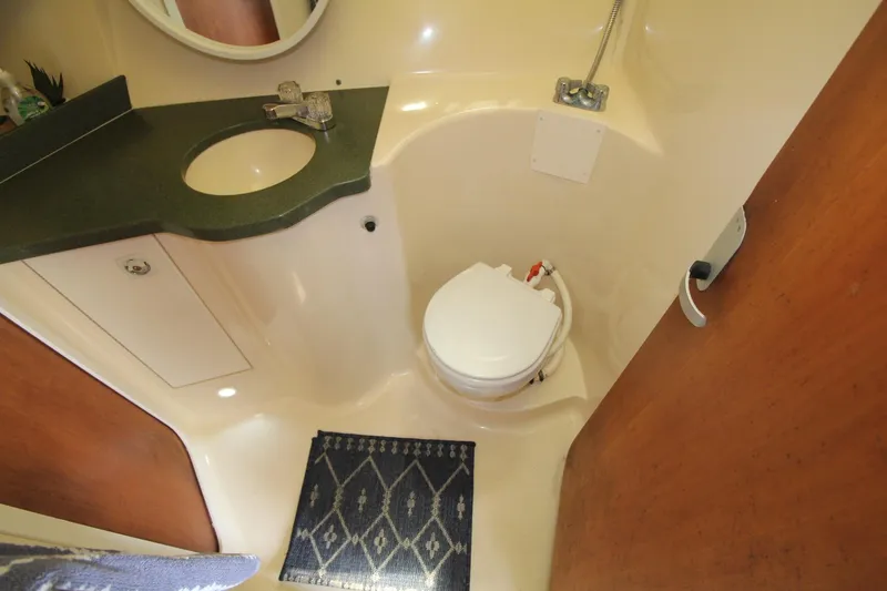Slide: The Image of 1999 Mainship 31 Sedan Bridge bathroom with sink, toilet, and shower area. - 28