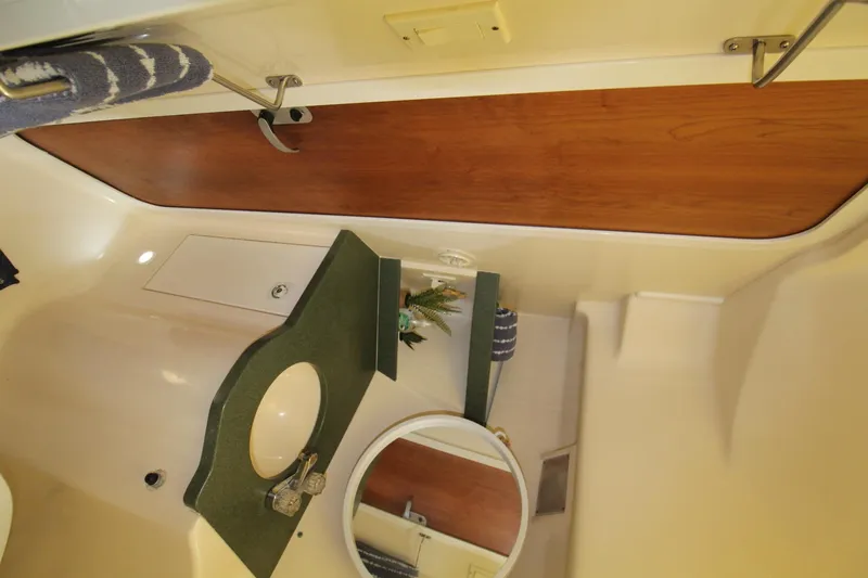 Slide: The Image of Interior of 1999 Mainship 31 Sedan Bridge bathroom with sink and mirror. - 29