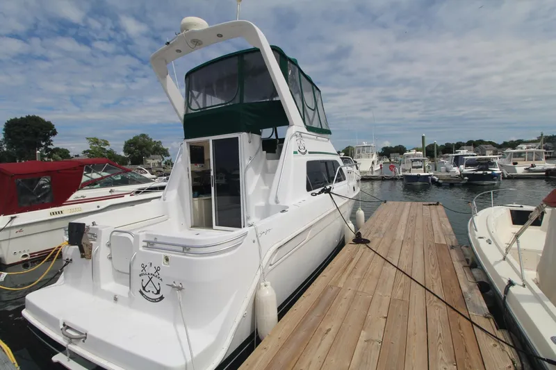 Slide: The Image of 1999 Mainship 31 Sedan Bridge docked at marina under partly cloudy sky. - 3