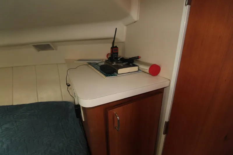 Slide: The Image of 1999 Mainship 31 Sedan Bridge cabin interior with storage cabinet and radio equipment. - 32