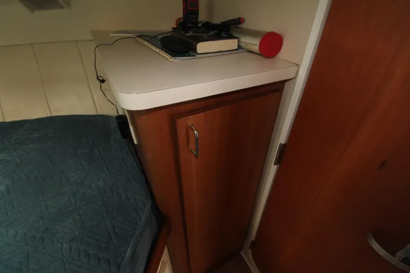 Slide: The Image of 1999 Mainship 31 Sedan Bridge cabin interior with wooden cabinet and bed. - 33