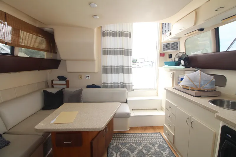 Slide: The Image of Interior of 1999 Mainship 31 Sedan Bridge with cozy seating and kitchenette. - 40