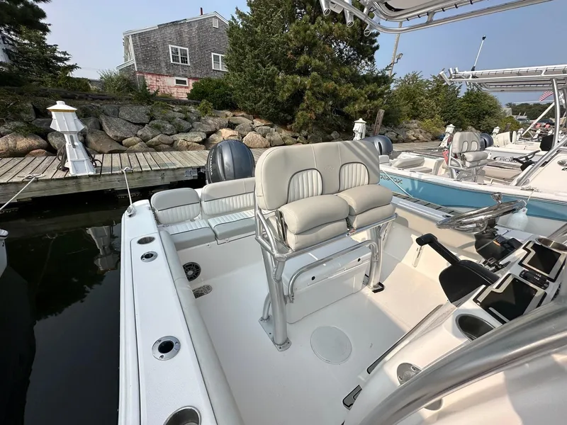 Slide: The Image of 2023 Sea Fox 228 Commander boat interior with seating and console at a dock. - 3
