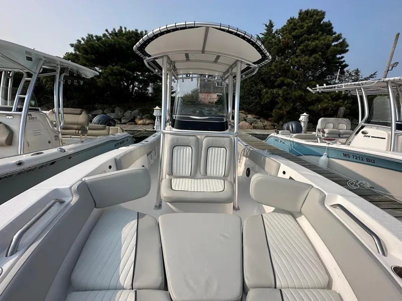 Slide: The Image of 2023 Sea Fox 228 Commander boat interior with seating and console, docked near other boats. - 6