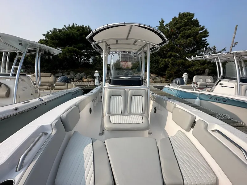 Slide: The Image of 2023 Sea Fox 228 Commander boat interior with seating and console, docked near other boats. - 7