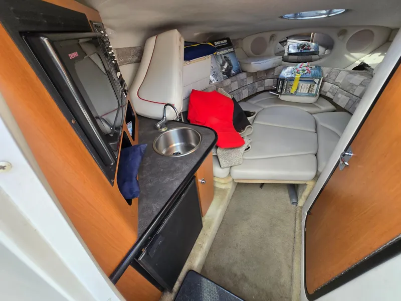 Slide: The Image of Interior of 2006 Crownline 255 CCR boat with kitchenette and seating area. - 15