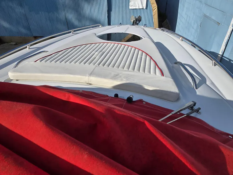 Slide: The Image of 2006 Crownline 255 CCR boat with red cover and white deck upholstery. - 21